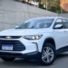 Chevrolet Tracker branca parada próximo de um muro na diagonal.