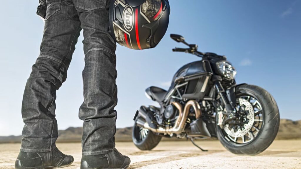 Motociclista segurando seu capacete e indo para sua moto.