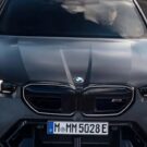 Frente da BMW M5 cinza escura na estrada.