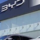 Dois carros da BYD em frente a uma loja da marca.