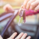 Pessoa entregando uma chave para uma outra pessoa.