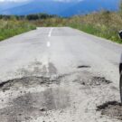 Carro passando em um buraco de dia.