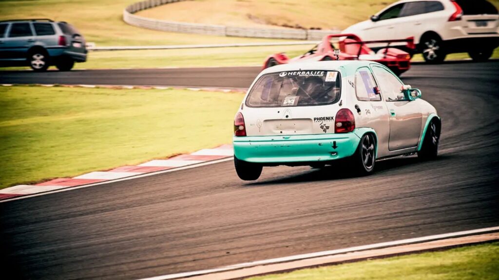 Cosa prata fazendo uma curva atras de vários carros.