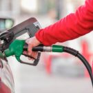 Pessoa abastecendo o carro cinza.