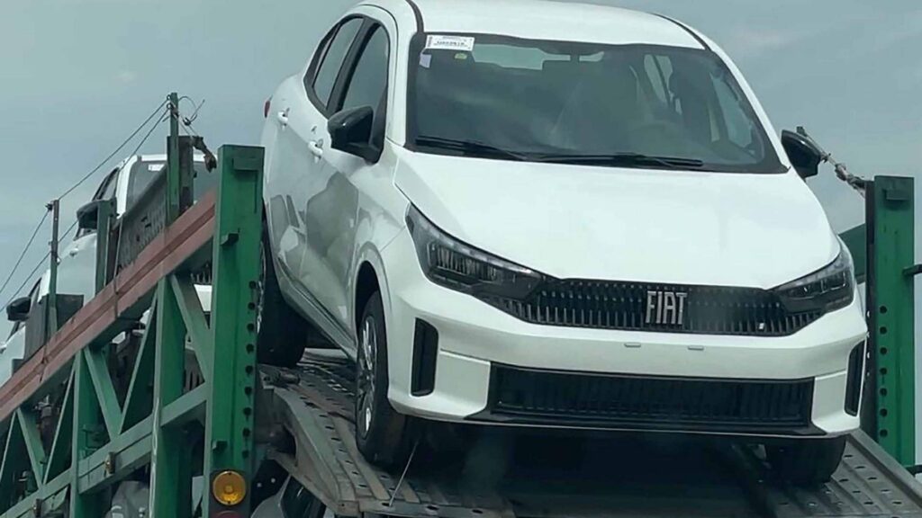 Novo Cronos 2026 branco saindo do caminhão.
