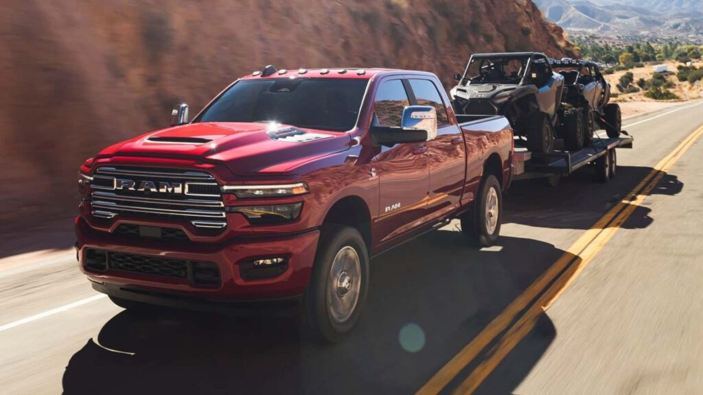 RAM vermelha na estrada com puxando dois carros.