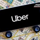 Celular com logo da Uber em cima do mapa.