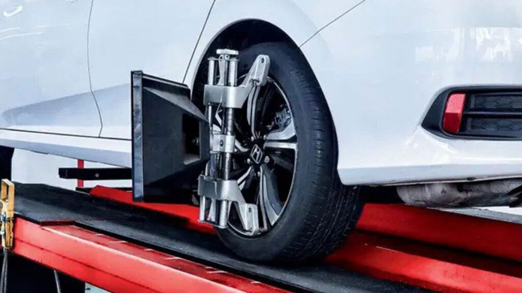 Carro branco fazendo alinhamento.