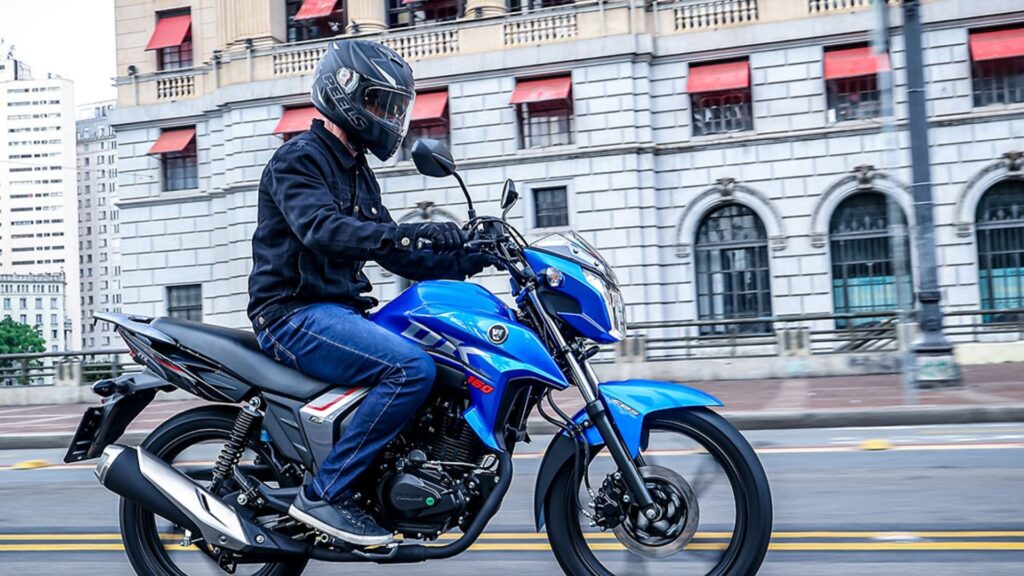 Haojue DK 160 CBS azul em movimento na estrada.