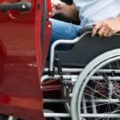 Pessoa PCD com seu carro que tem isenção de IPVA.