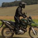 Pessoa em cima de uma Moto Trail da Yamaha com seu capacete próprio para trilha.