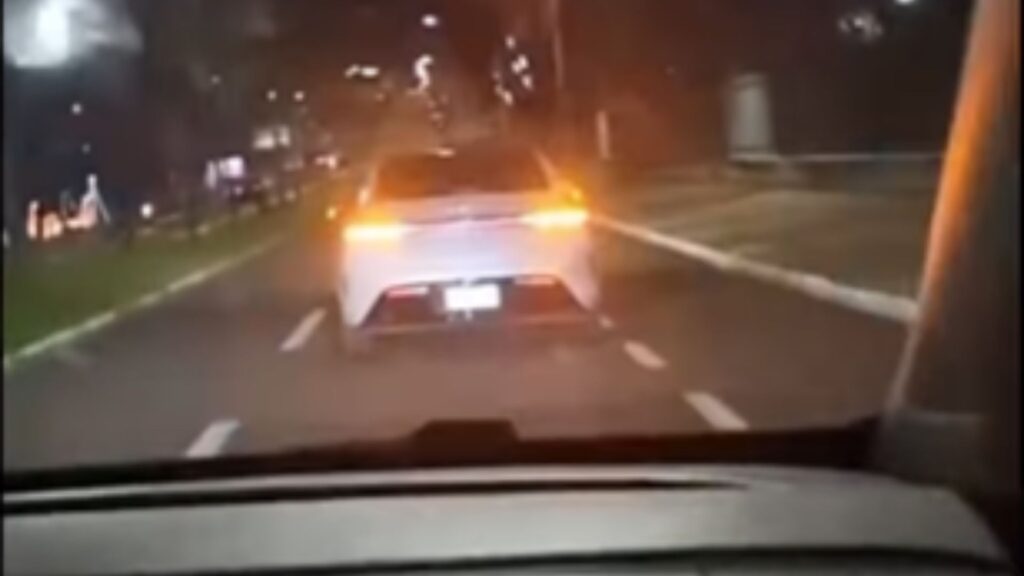 Carro branco com o pisca-alerta aceso por conta de brincadeira da internet.