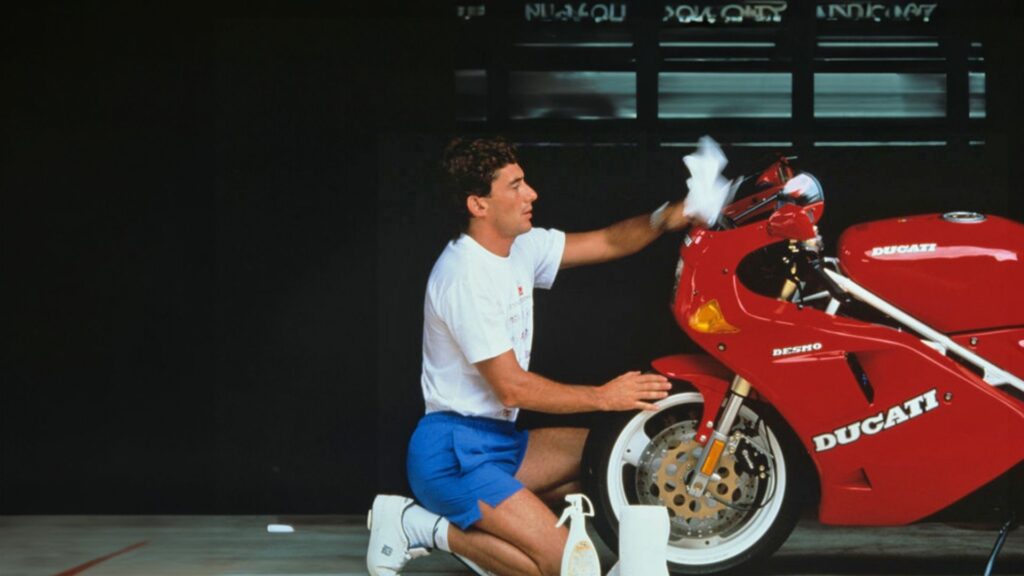 Senna lavando uma moto vermelha da Ducati.