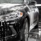 Carro preto sendo lavado.