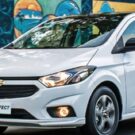Chevrolet Onix Effect 2016 branco com os faróis acesos.