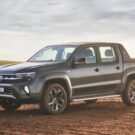 Amarok V6 2025 cinza escuro na diagonal em uma estrada de terra.