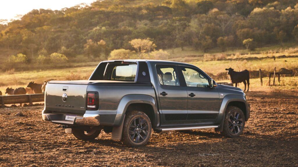 Traseira da Amarok V6 2025 cinza parada próximo de uns bois.