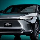 Toyota bZ4X cinza na diagonal em um fundo verde.