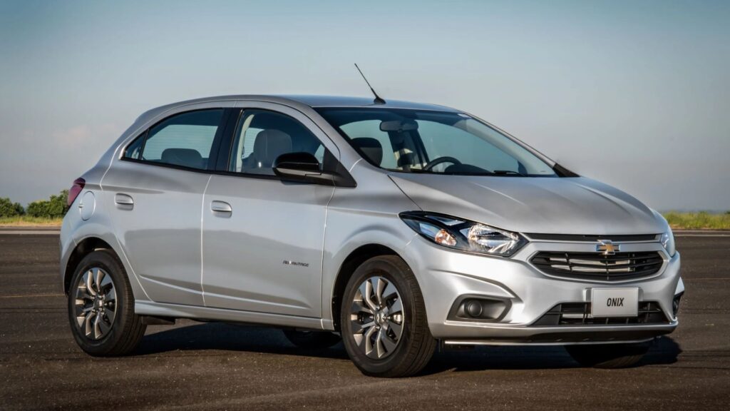 Chevrolet Onix prata na diagonal.