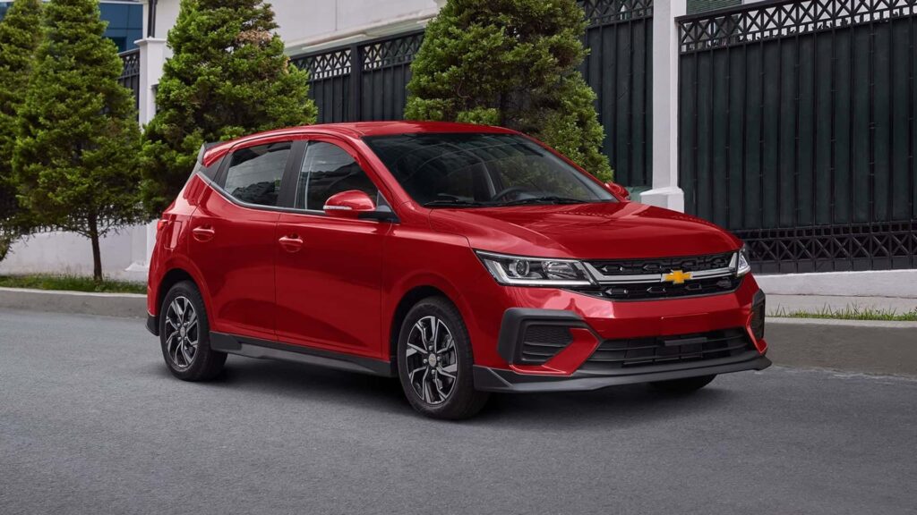 Chevrolet Aveo 2025 vermelho na diagonal em uma estrada.