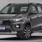 Fiat Strada Freedom 2026 cinza escuro na diagonal em um fundo cinza escuro.