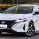 Nissan Sentra branco na diagonal parado.