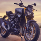 Honda CB1000 Hornet parada na diagonal com os faróis ligados com o por do sol no fundo.