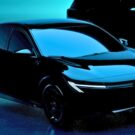 Nissan Sentra 2026 na diagonal em um fundo verde agua.