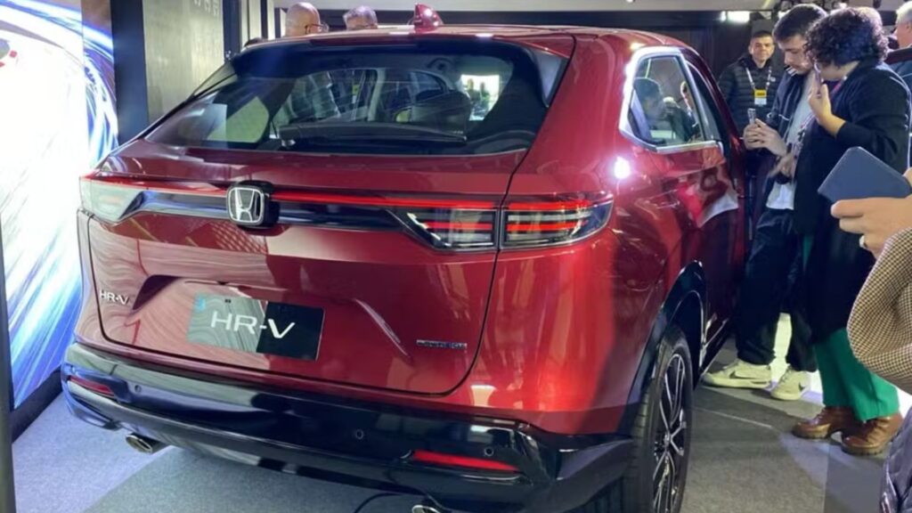 Traseira do Honda HR-V 2026 vermelho em uma exposição com várias pessoas ao seu redor.