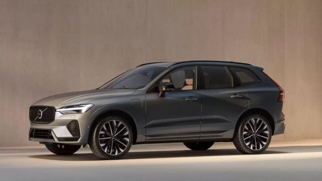 Volvo XC60 2026 cinza de lado em uma parde clara.