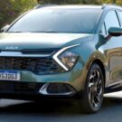 Carro híbrido da Kia verde em movimento na estrada