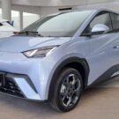 BYD Dolphin Mini 2026 azul na diagonal dentro de uma loja.