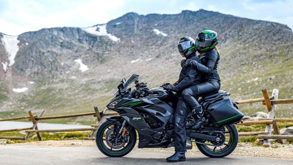 Kawasaki Ninja 1100SX 2025 preta com dois motociclistas em cima.