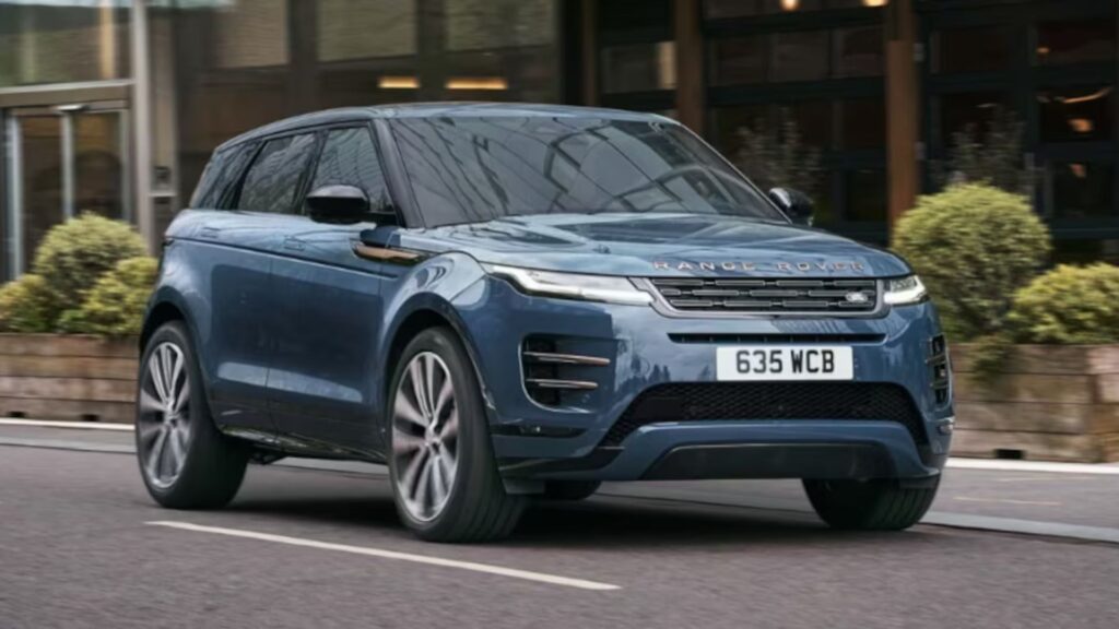 Range Rover Evoque 2026 azul em movimento na estrada com os faróis acesos.