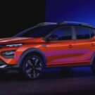 Renault Kardian laranja parado na diagonal em um fundo escuro.