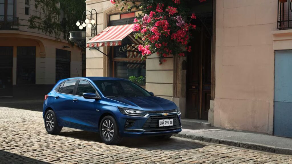 Chevrolet Onix azul parado na beirada da estrada.