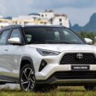 Toyota Yaris Cross branco na diagonal com um rio no fundo.