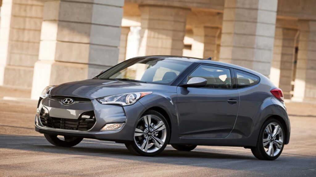 Hyundai Veloster cinza parado na diagonal.