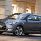 Hyundai Veloster cinza parado na diagonal.