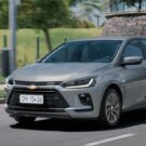 Chevrolet Onix Plus 2026 prata de frente na estrada.