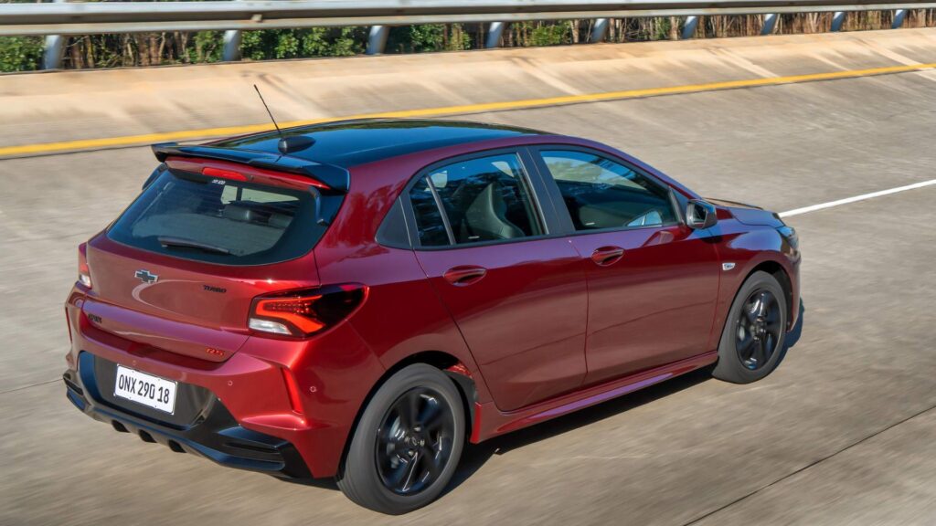 Chevrolet Onix RS 2026 vermelha em uma estrada.