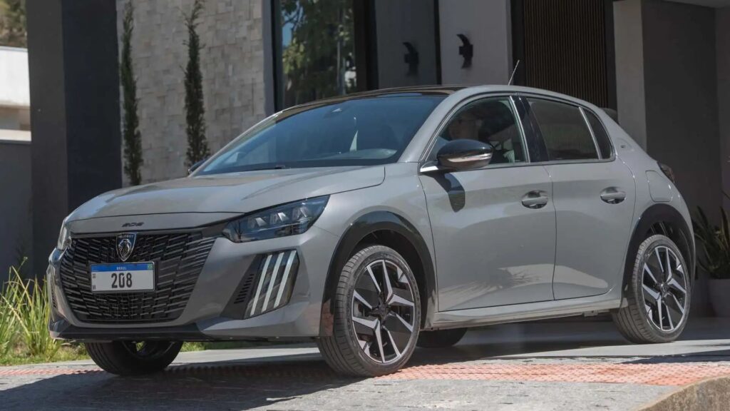 Peugeot 208 Active 2025  cinza parado na frente de uma garagem.