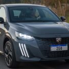 Peugeot 208 GT cinza com os faróis acesos.