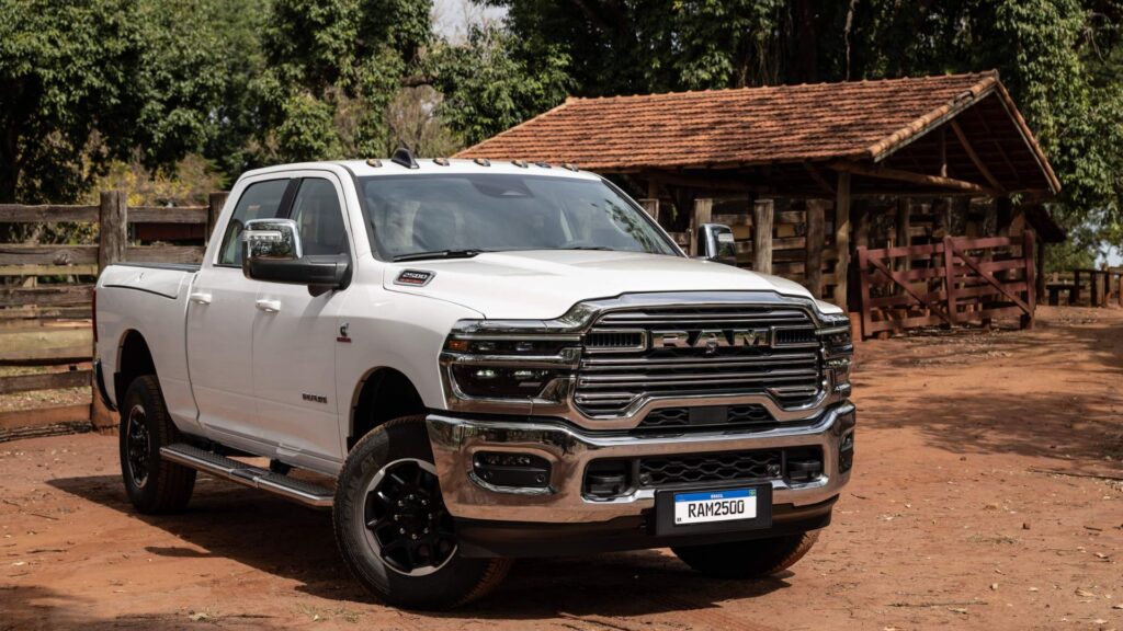Ram 2500 2026 branca parada na diagonal em uma estrada de barro.