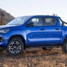 Hílux Híbrida azul parada na diagonal.