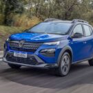 Renault Kardian 2026 azul em movimento em um asfalto com mato na beirada da estrada.