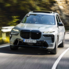 BMW X7 cinza em movimento na estrada.