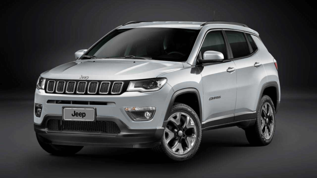 Jeep Compass branco parado na diagonal em um fundo preto.