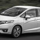 Honda Fit branco na estrada.