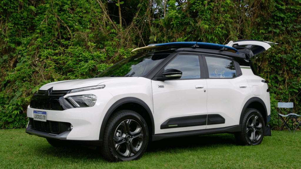 Citroën Aircross XTR branco parado na diagonal com uma prancha em cima.